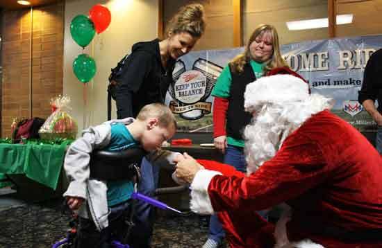 Santa shakes Zachary Kash’s hand as his mother