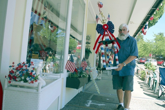Tom Dorsey displays the trophy Bothell Main Street Antiques won for its storefront display.