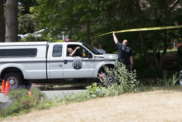 A medical examiner vehicle arrives at the scene of the fatal Bothell house fire after investigators poured over the scene earlier in the day.