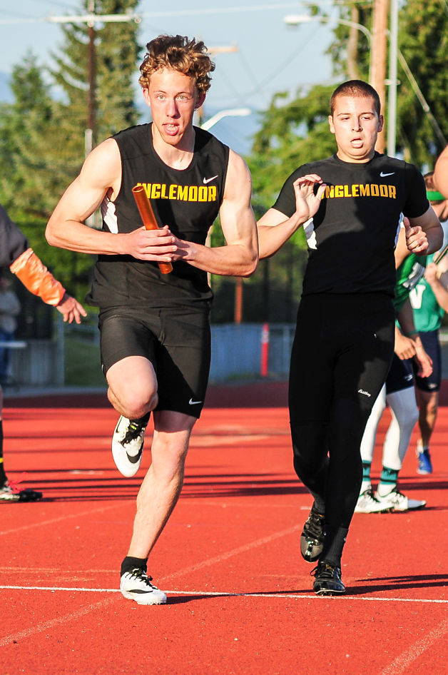 Inglemoor High School runner Micheal Rhoads takes the baton from teammate Ryan Larson as they prepare for the finals of the 1
