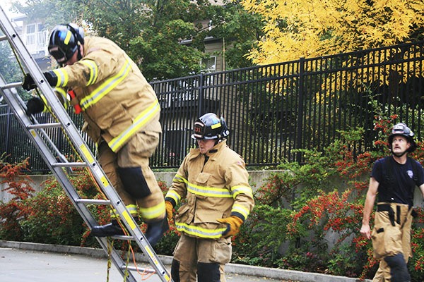 Woodinville Fire and Rescue new hires practice lowering fire victims from flaming buildings at the Northshore Fire Department Station 51 training center.