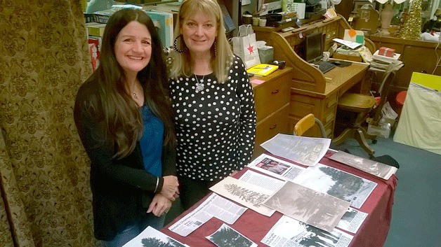 Linda Dorsey and Nancy Pipinich showcase a week’s worth of research and newspaper clippings on the Bothell Christmas tree