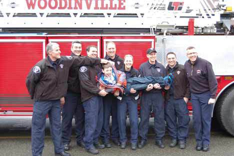 Members of Bothell Fire and EMS and Woodinville Fire and Rescue give Will Fischer a lift at the Wellington Elementary event. The are