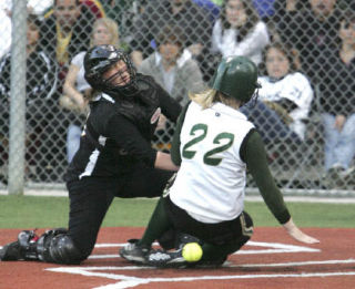 Inglemoor High catcher Amy Taylor braces herself for a collision with Redmond High’s Emily Squiers at home plate during a Kingco 4A Tournament game at Hartman Park in Redmond May 15. Squiers was safe at the plate. The Mustangs beat the Vikings