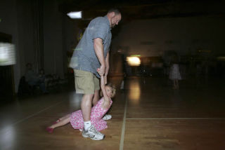 Tim Smith swings his daughter Madison through his legs on the dance floor.