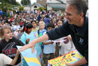 Students hand off cards to retiring Woodmoor Elementary Principal Steve Wharton during a day in his honor June 17 at the Bothell school. He’s worked in local schools for 32 years.