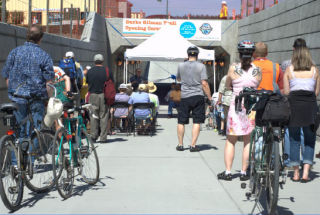 Kenmore community members prepare to ride while listening to Washington State Transportation Improvement Board Executive Director Steve Gorcester speak about the significance of the new Burke-Gilman Trail 73rd Avenue Northeast underpass June 28. Kenmore Mayor David Baker