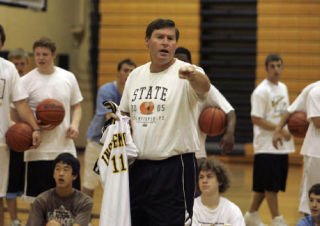 Players listen intently as coach Greg Lowell speaks during the Inglemoor High boys basketball camp last Wednesday. About 60 athletes attended the week-long camp. “Lowell teaches a lot of fundamentals and stuff that really helps you play good basketball