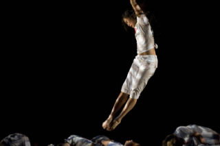 Jennifer Lin leaps over other dancers during a performance.