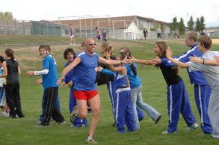 Bothell High track co-coach Robert Eichelsdoerfer (Cougar class of 1980) high-fives members of the cross-country team in 2006.