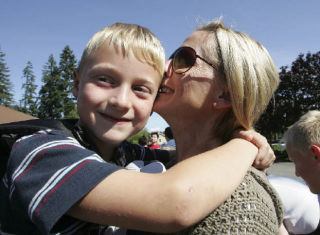 Canyon Creek Elementary School student Nicholas Welp gets a hug and kiss from his mother