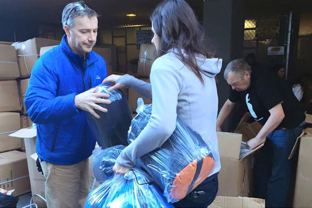 Sleepless in Seattle volunteers prepare to distribute sleeping bags, mats and care packages to the homeless at a previous event. Contributed photo