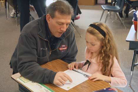 Northshore Fire Department Lt. Steve Loutsis discusses the home escape plan put together by Moorlands Elementary student Kaitlynn Parpart.