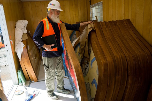 Mike McMenamin looks through individually painted headboards for his new business in downtown Bothell.