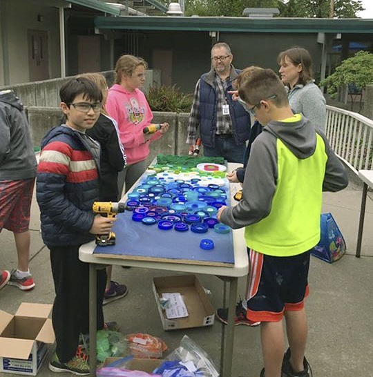 Students at Moorelands Elementary in Kenmore work on a school mural on Friday