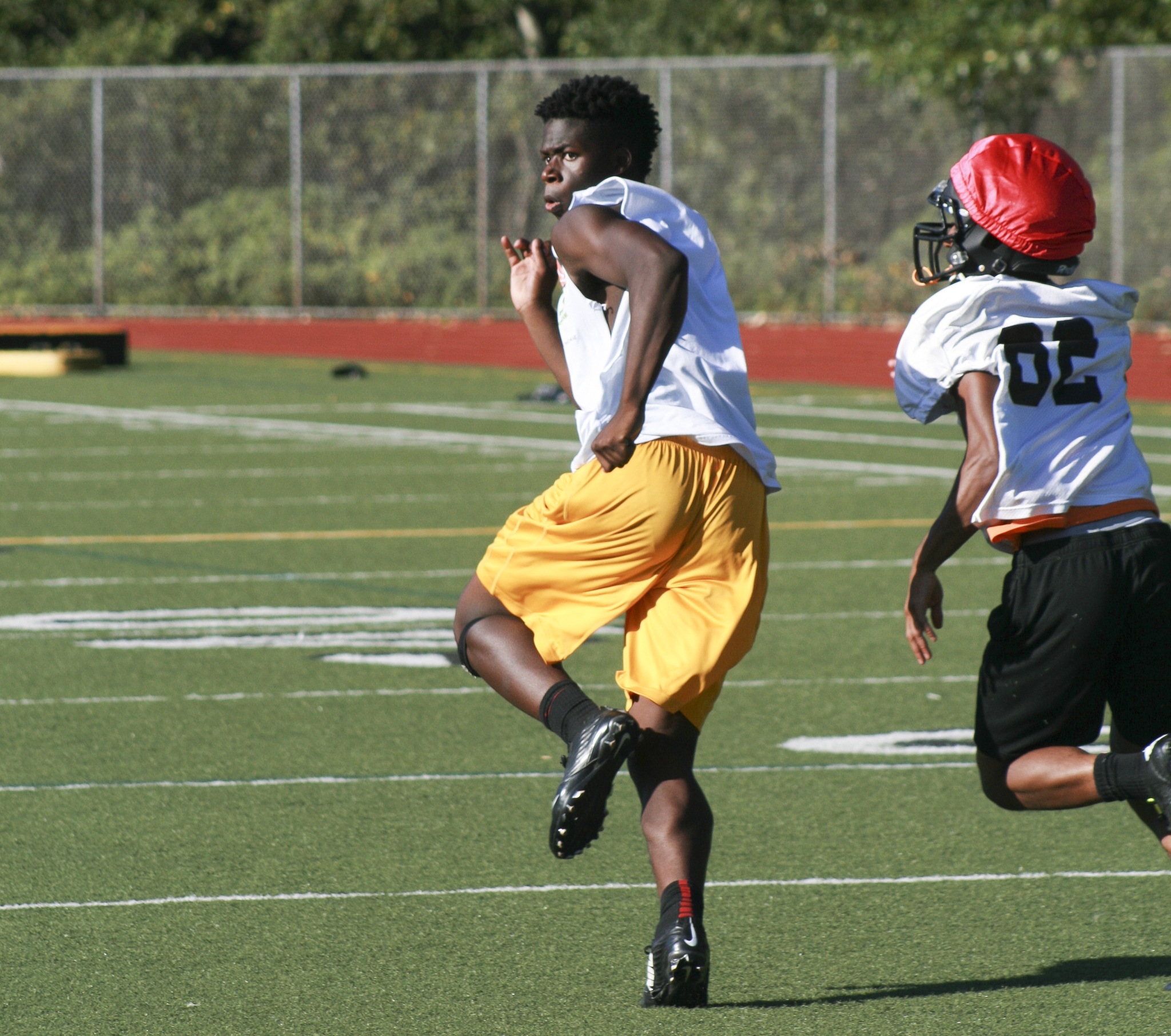 Inglemoor senior Chinedu Ugokwoli runs away from a defensive back during preseason training. Already a standout basketball player