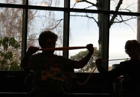 Seniors stretch their arms with large rubber bands.