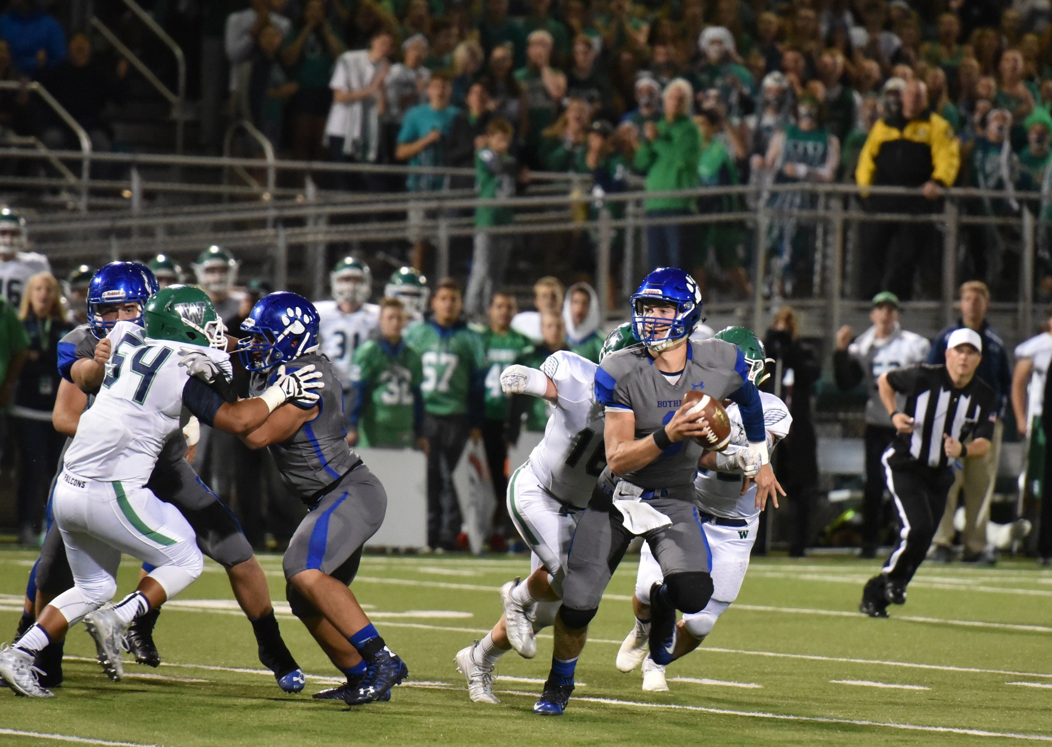 Bothell quarterback Jacob Sirmon is chased by a pair of Woodinville defensive lineman in the first half of Friday’s 17-10 Bothell loss at Pop Keeney Stadium. Photo courtesy of Greg Nelson.