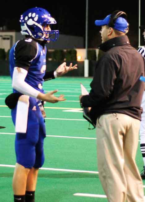 Bothell High quarterback Mitchell Muller discusses strategy with head coach Tom Bainter during the Cougars’ recent 4A Kingco championship win over Skyline High.