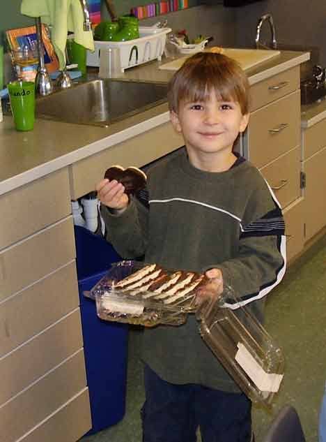 Jason Brockmeyer hands out the Christmas cookies he bought for his classmates with some of his prize winnings.