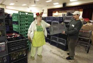 Bothell Hopelink’s Jim Forsman hands an empty milk carton over to volunteer Ann Barnhart at Hopelink’s food bank Nov. 25.