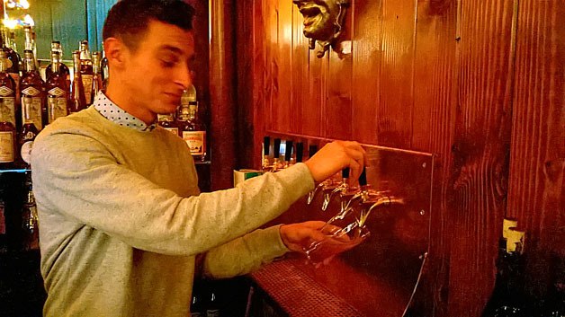 A bartender pours a beer for one of the first customers at the Anderson School McMenamin’s in downtown Bothell during a pre-opening party on Tuesday. The event was through invitation only but the new business will hold a full grand opening celebration tonight with live music from the Young Fresh Fellows.