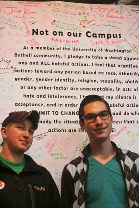 Heather Meyer-Love and Drue Nyenhuis stand in front of the “Not On Our Campus” pledge.