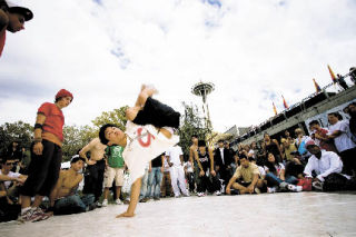 A breakdancer shows off his moves in the Seattle Center during last year’s Bumbershoot music and arts festival. The event — which features live music