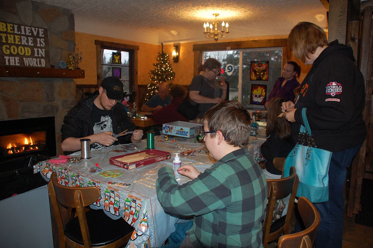 Patrons at Zulu’s Board Game Cafe in Bothell create holiday ornaments made from old board game pieces. Contributed photo