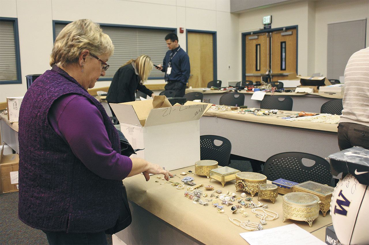 Gail Genereau of Lake Forest Park scours the items recovered from the “Movie Bandits” burglaries in 2012 at the Redmond Police Department as the result of a Pro-Act investigation. She found some of her stolen jewelry. File Photo