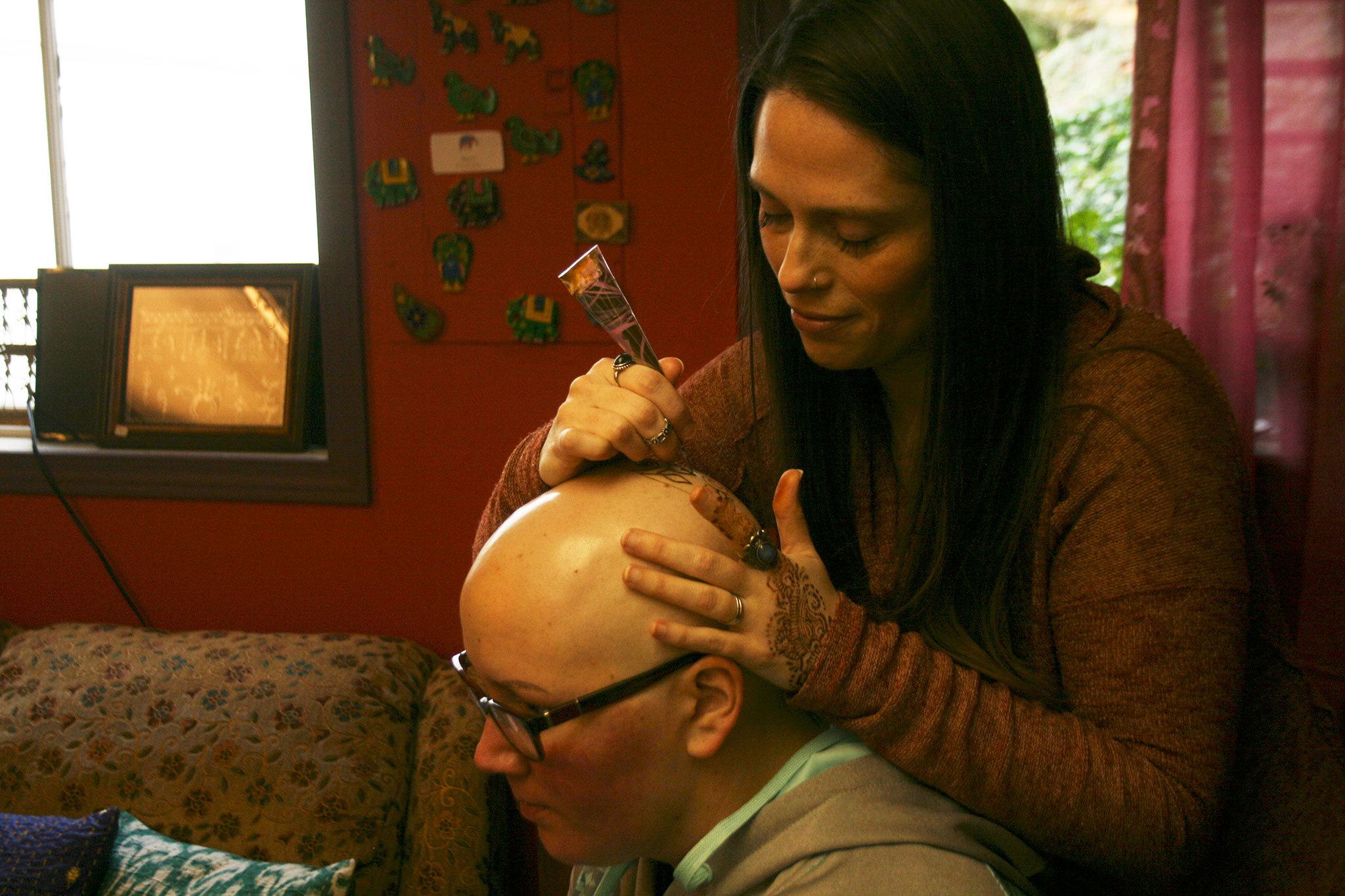 Kirkland artist Sarah Walters creates a henna crown for Mary Glasco at Sankara Imports in Bothell. CATHERINE KRUMMEY/Kirkland Reporter