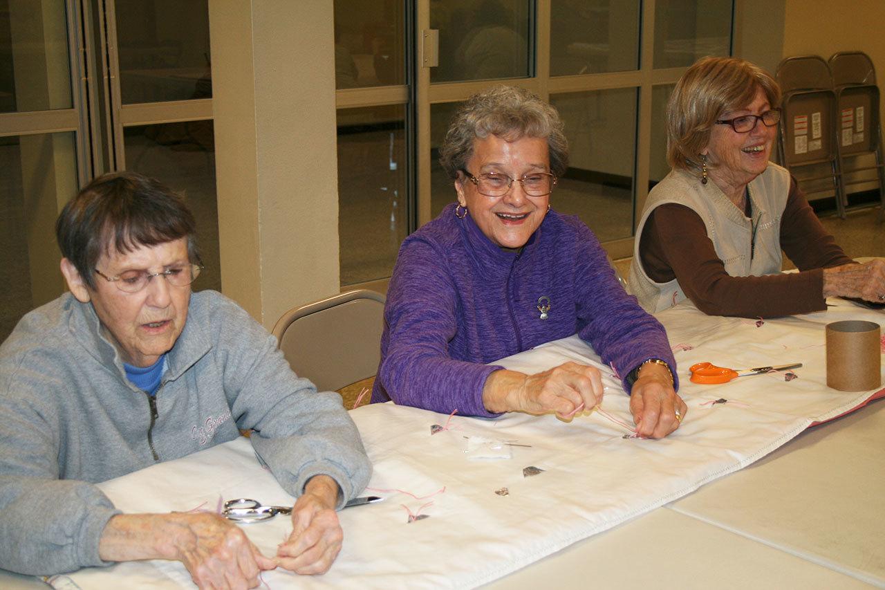 Charlene Maxfield, Erika Beers and Carlene Russell work on a quilt at First Lutheran Church of Bothell on Feb. 2. CATHERINE KRUMMEY / Bothell Reporter