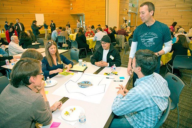 Peter Kageyama (standing at right) discusses a T-shirt design with Kenmore residents at a “For the Love of Kenmore” event in 2015. Kageyama will host another workshop on April 3 at Kenmore City Hall. Reporter file photo