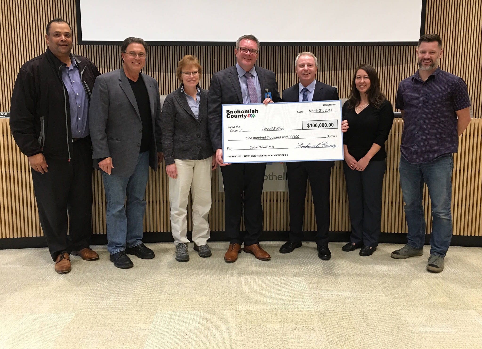 The Bothell City Council is presented with a $100,000 check from Snohomish County. From left to right are Bothell City Councilmember James McNeal, City Councilmember Tom Agnew, City Councilmember Tris Samberg, Mayor Andy Rheaume, Snohomish County Councilmember Terry Ryan, Deputy Mayor Davina Duerr and City Councilmember Joshua Freed. Contributed photo