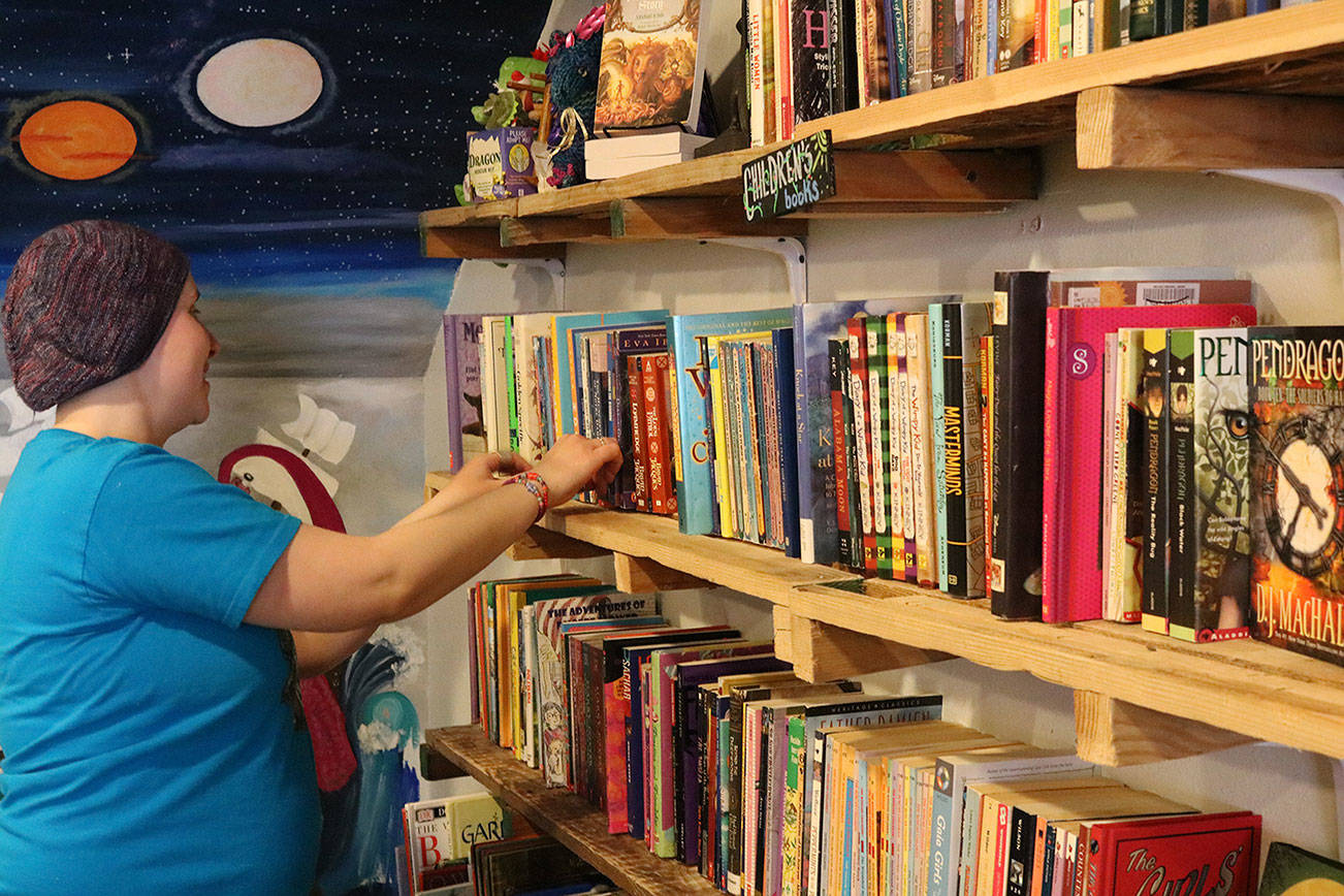 The Neverending Bookshop owner Annie Carl rearranges the children’s section in her Bothell shop ahead of Independent Bookstore Day. CATHERINE KRUMMEY/Bothell Reporter