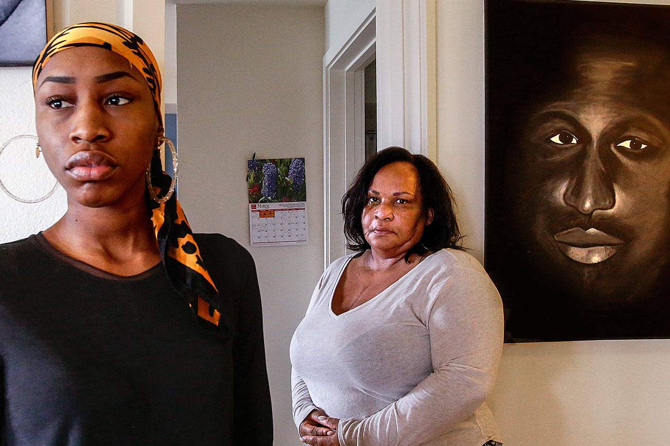Youngest daughter, Rhonda Faison, 28 (left) and her mom Patricia Faison meet at Patricia’s Lynnwood home, March 15 to talk about brother and son, Henry Faison, depicted in photo (top) and painting by Jason Fox (right). (Dan Bates / The Herald)