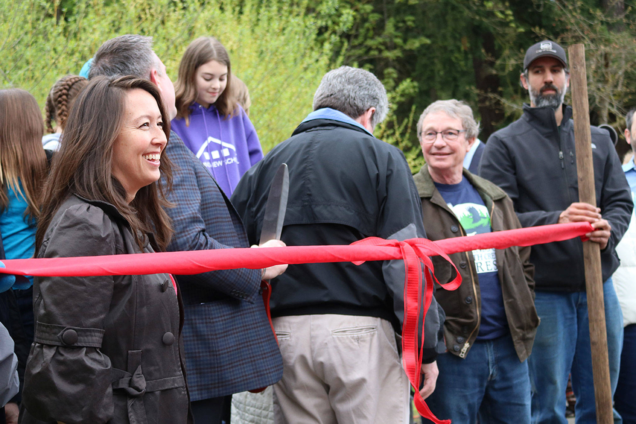 Local officials, including Bothell Deputy Mayor Davina Duerr, and others involved in the acquisition process prepare to cut the ribbon to celebrate the city’s procurement of all of North Creek Forest. CATHERINE KRUMMEY / Bothell Reporter
