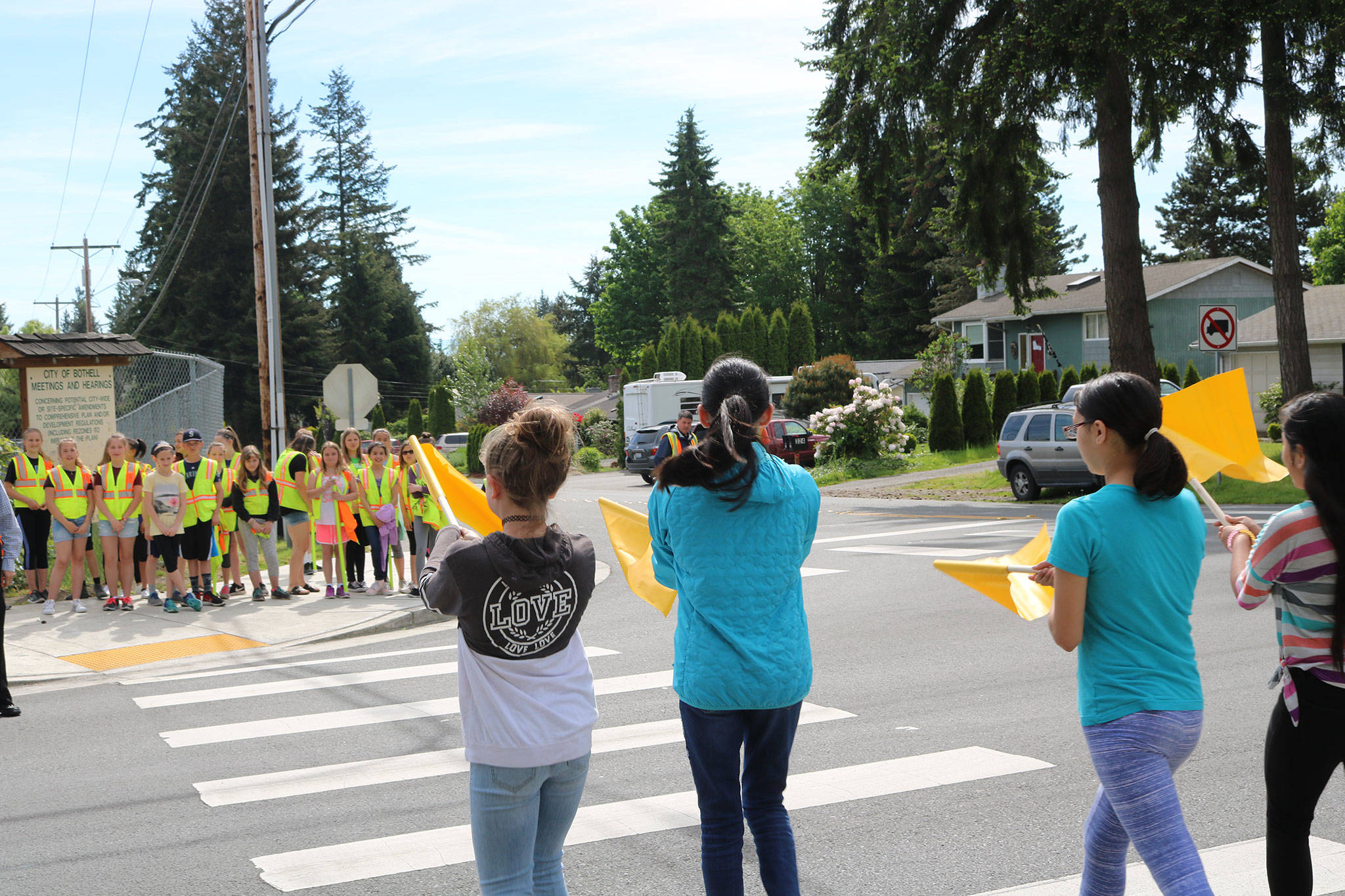Frank Love Elementary School students use the new pedestrian flags at the intersection of Fourth Avenue West and 224th Street Southwest. CATHERINE KRUMMEY / Bothell Reporter
