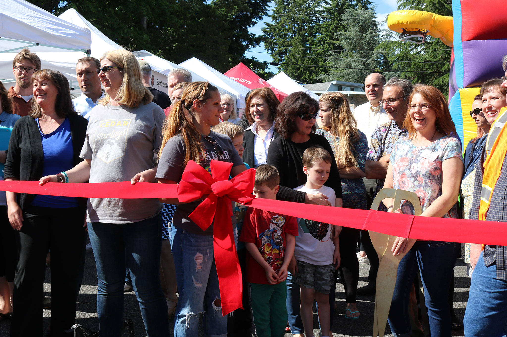 Kenmore Community Market manager Jenni Jensen (with the scissors) prepares to cut the ribbon to celebrate the market’s opening. CATHERINE KRUMMEY / Bothell-Kenmore Reporter