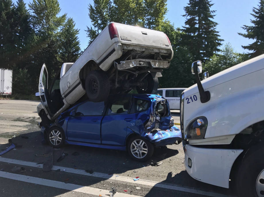 A semi truck plowed into a Honda Fiat yesterday on I-405, pushing the vehicle underneath a Chevrolet truck. Contributed photo/Washington State Patrol