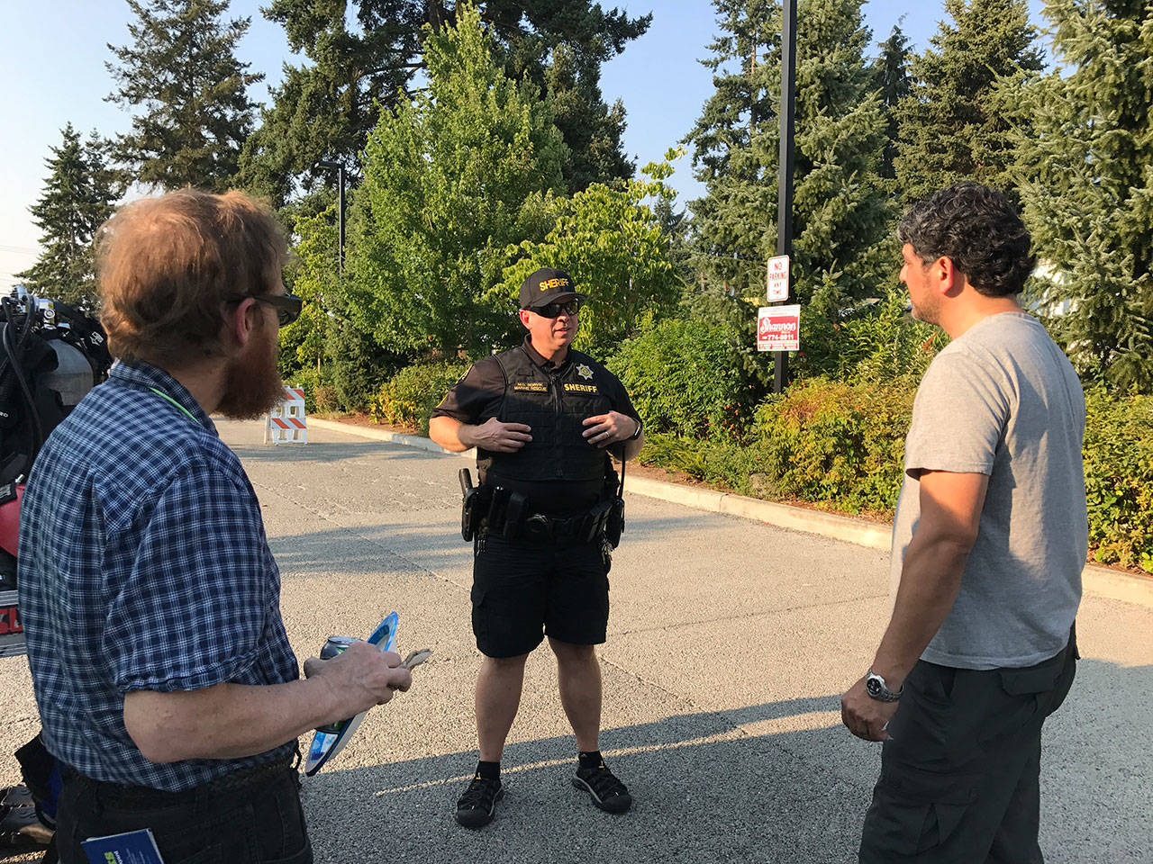 A King County deputy discusses public safety matters with Kenmore residents. Samantha Pak, Bothell-Kenmore Reporter