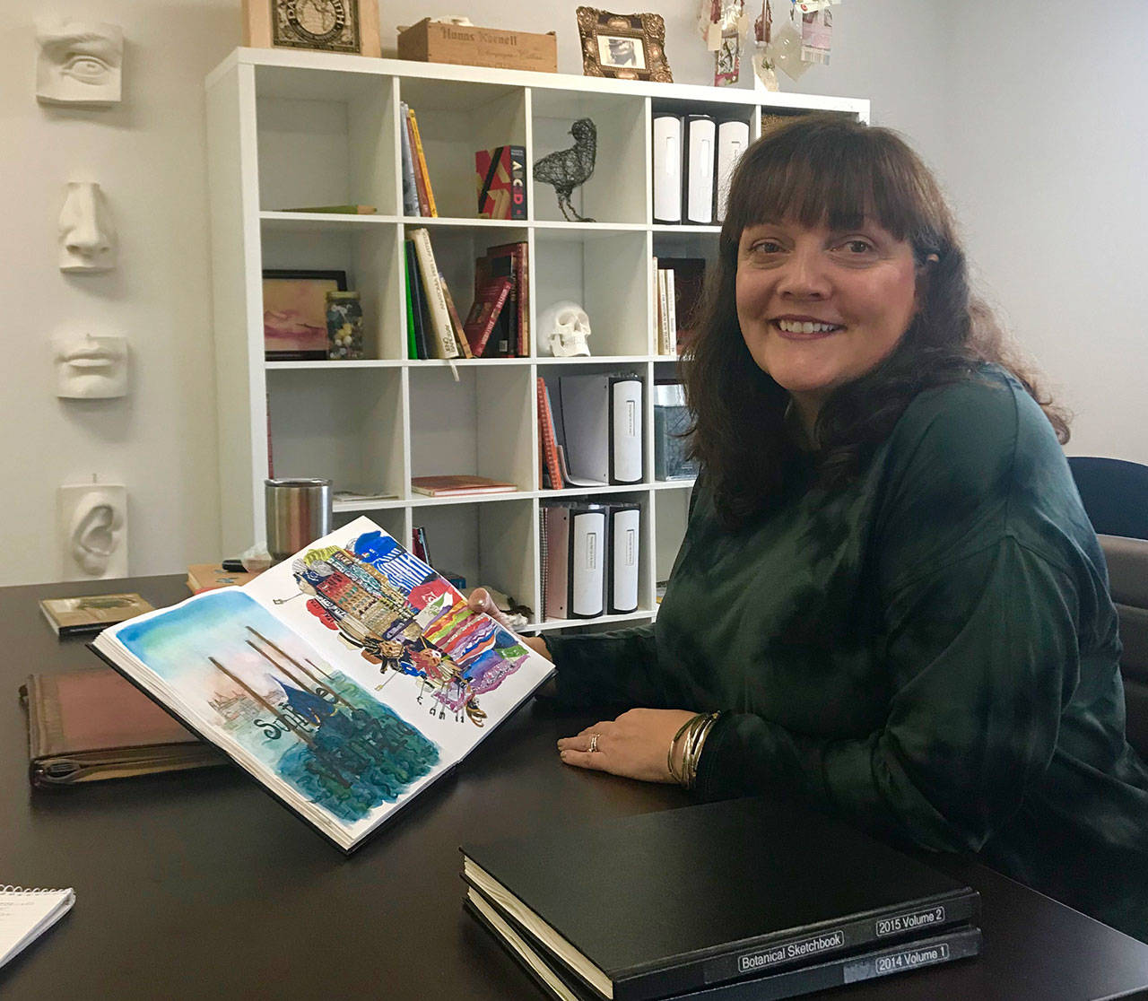 Charlene Collins Freeman showcases one of her watercolor sketchbooks in Cloud 9’s meeting room. Several sketchbooking classes are offered at the art school. Courtesy of Blake Peterson