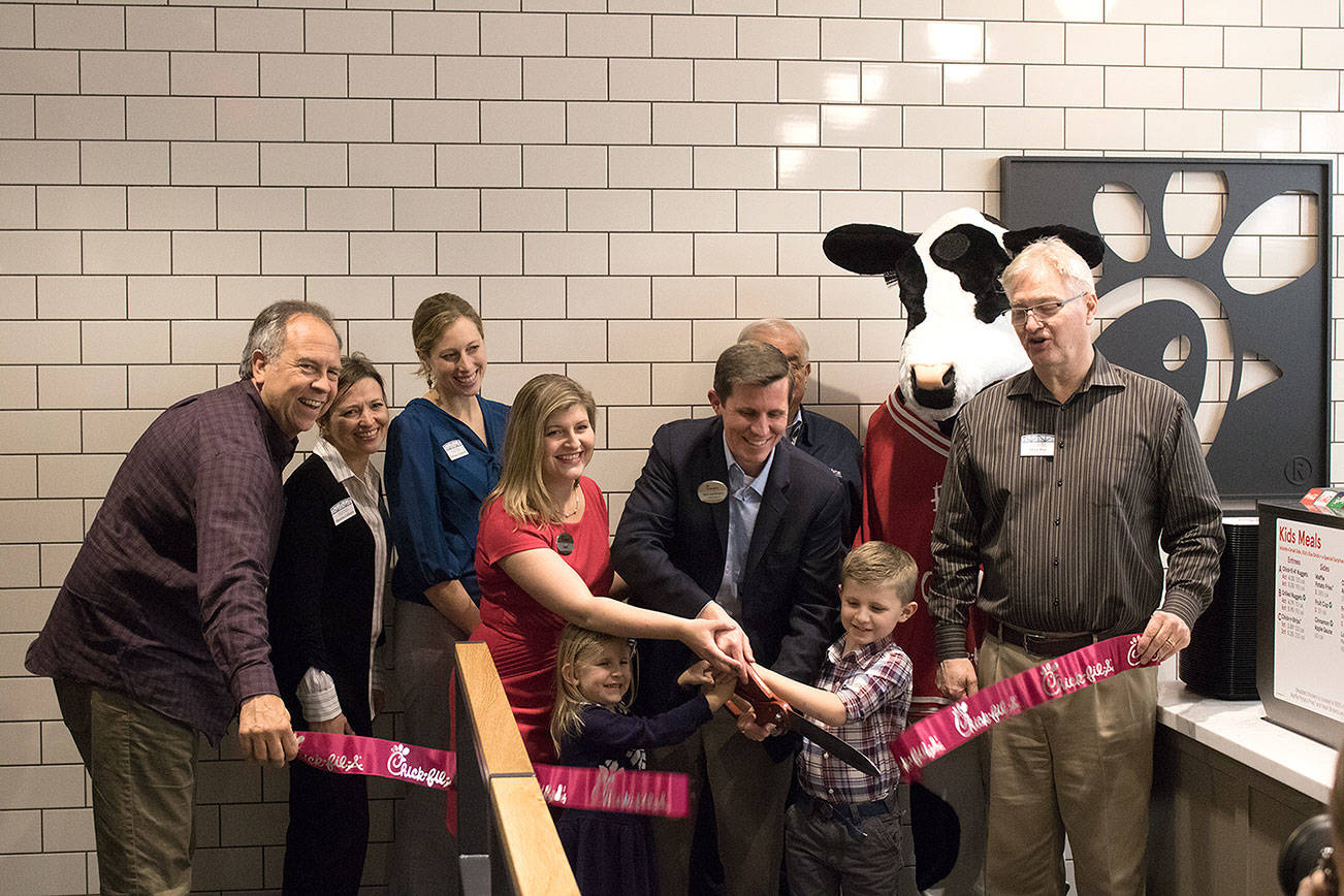 Matt Isenhower, owner and operator of the Canyon Park Chick-fil-A, cuts the ribbon with his family and Bothell Chamber of Commerce members during the preview night celebration. Kailan Manandic, Bothell/Kenmore Reporter
