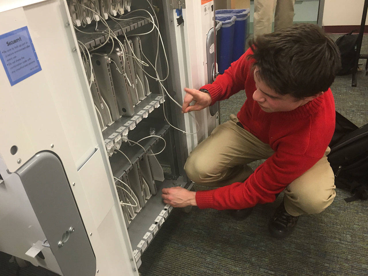A student at Woodinville High School picks out a computer from a cart. Courtesy of Northshore School District