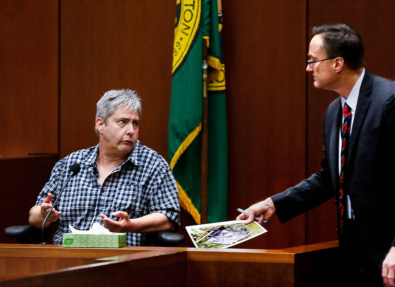 After showing Tony Reed (left) an evidence photo Tuesday, Snohomish County chief deputy prosecutor Craig Matheson listens as Reed testifies. (Dan Bates / The Herald)