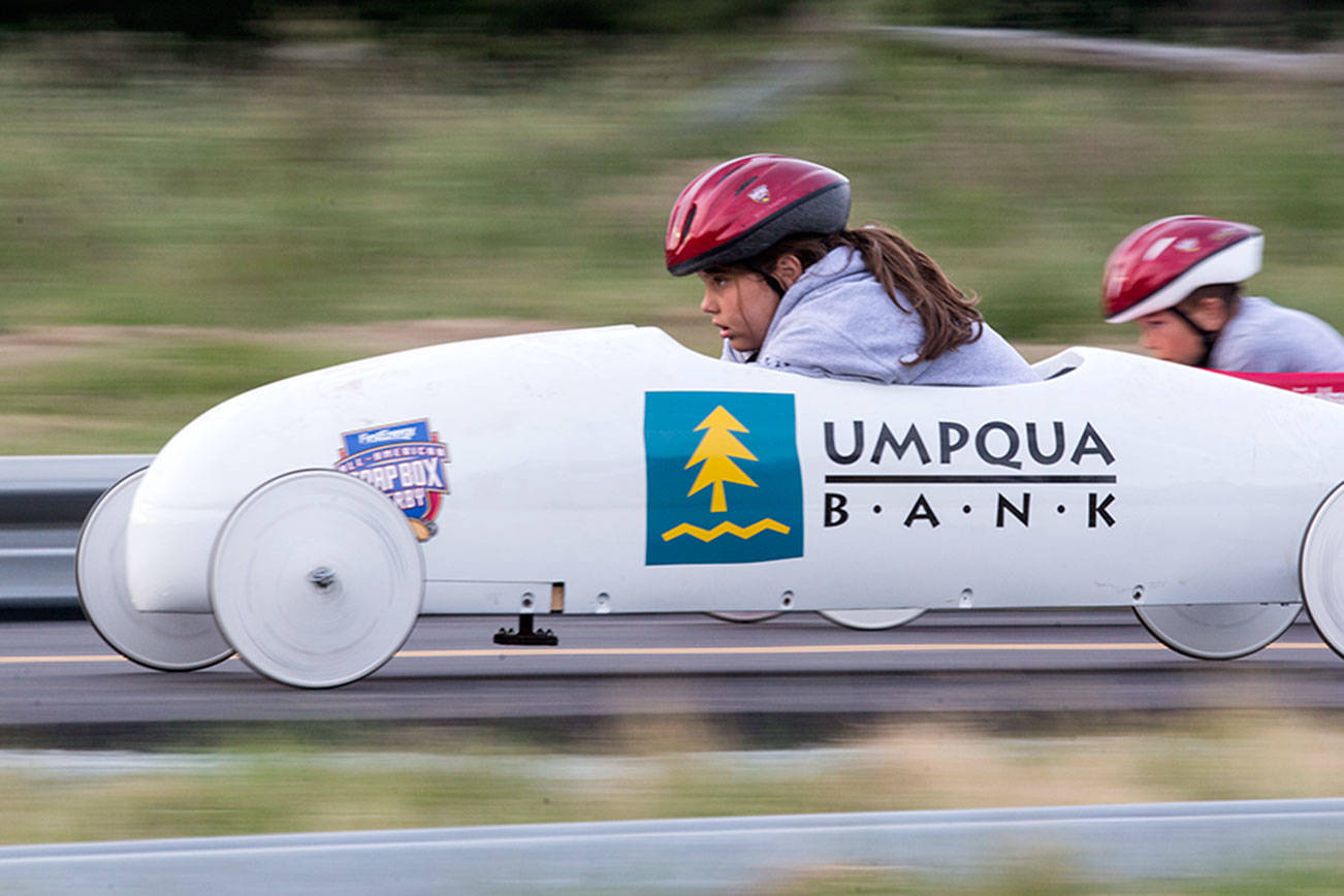 Amelia Allen (left) looks down at the track as she races another driver in unweighted practice soap box derby cars June 7 on Camano Island. The 11th Stanwood-Camano Soap Box Derby takes place Saturday. (Andy Bronson / The Herald)