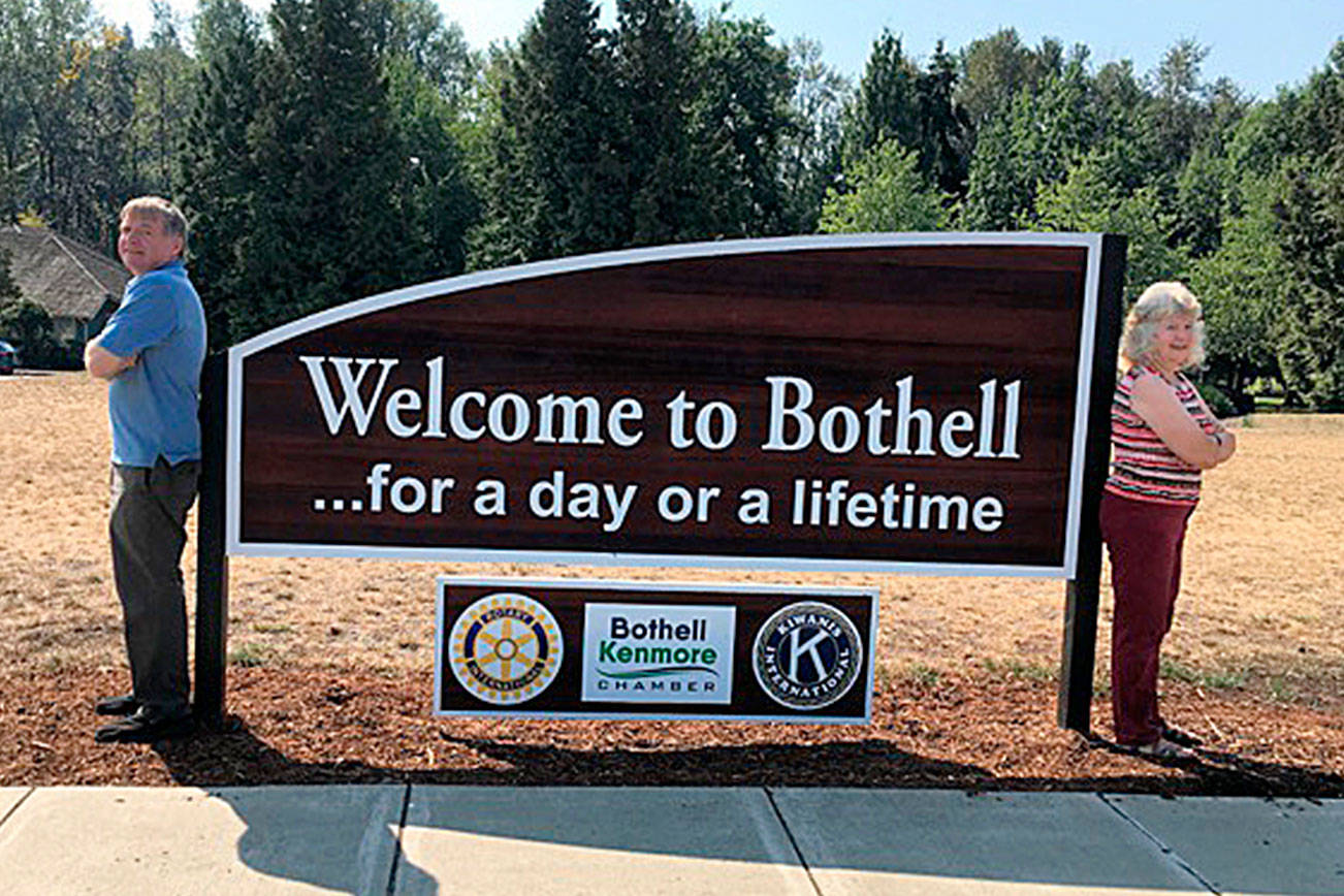 Richard Olson and Susan Gardner bookend the new sign. Photo courtesy of Richard Olson.