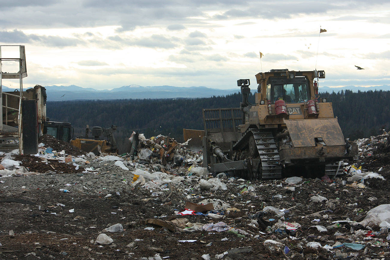 A tractor moves to push trash away from where it was emptied from a cargo trailer atop the Cedar Hills Regional Landfill. An eighth and final section of the landfill is almost ready to come online, extending the life of the landfill through 2028. Aaron Kunkler/staff photo