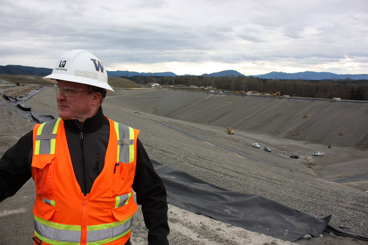 Scott Barden stands next to the pit that will house the newest, and possibly final, section of the Cedar Hills Regional Landfill near Maple Valley. The pit is 120 feet deep, and around another 180 feet will be built on top of it over the next decade. Aaron Kunkler/staff photo
