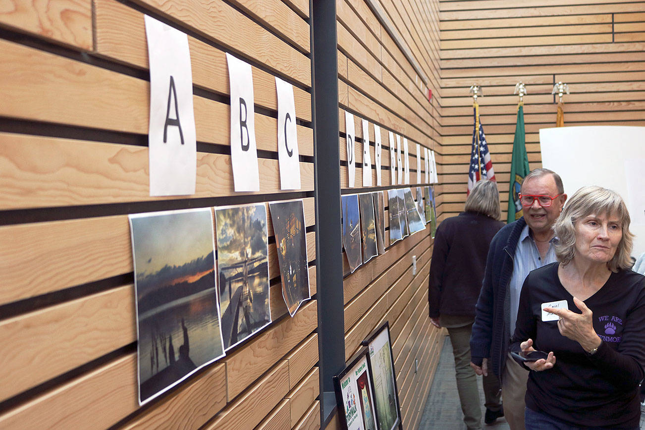 Workshop attendees examine vote on their favorite photo from the “For the Love of Kenmore” photography contest. Kailan Manandic/staff photo